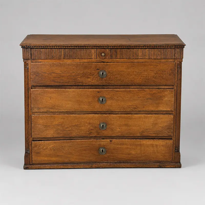 Antique Swedish oak classical chest of drawers with four drawers, reeded frieze, column details, and round metal escutcheons.
