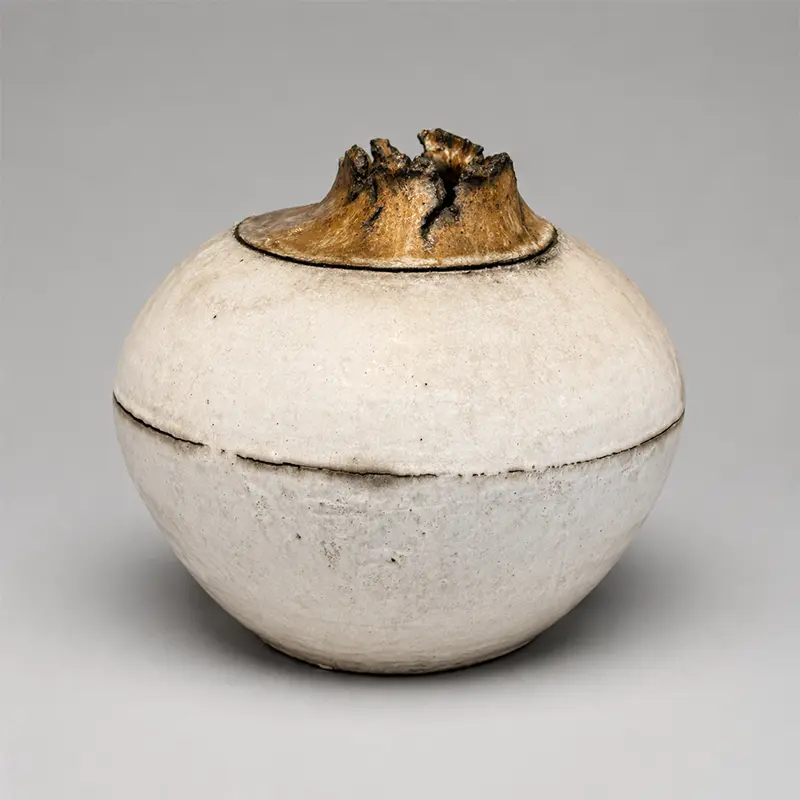 Japanese sculptural stoneware vessel with white glaze and dramatic ochre volcanic rim, Japan, late 20th century.