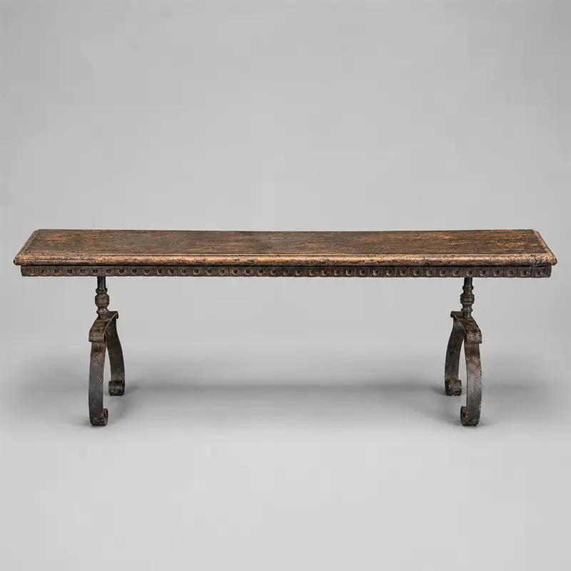 Continental wrought-iron and carved wood hall table with scrolling trestle legs and distressed 19th-century top.